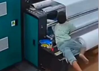 Câmera registra momento em que criança tem braço puxado por máquina de impressão